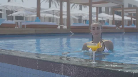 Girl in the pool drinking cocktail Stock Footage 93442103