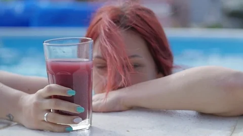 Girl by the pool drinking juice Stockbeeldmateriaal 79639728