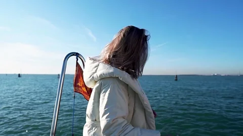 A girl poses on the deck of a ship that is sailing to Venice Stock Footage 262425824