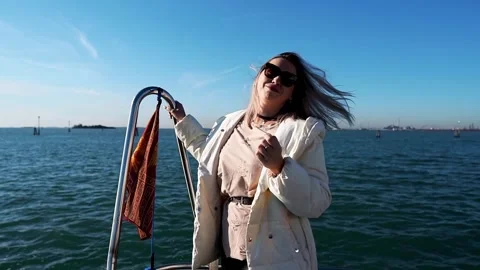 A girl poses on the deck of a ship that is sailing to Venice Stock Footage 262425825