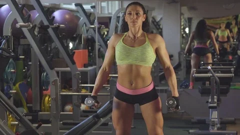 Girl posing with dumbbell in front of a mirror sportzalle Stock Footage 70383229