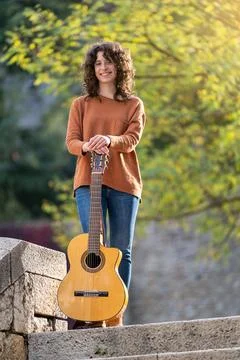 Girl posing in front of the camera with her spanish guitar Stock Photos
