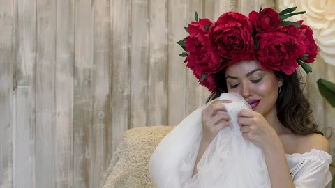 Girl posing in front of camera. young woman in a wreath of scarlet peonies on Stock Footage 88151144