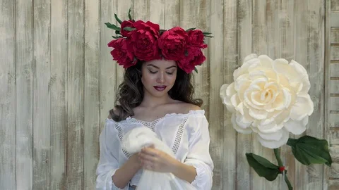 Girl posing in front of camera. young woman in a wreath of scarlet peonies on Stock Footage 88408685