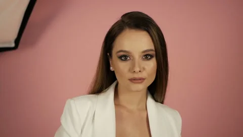 Girl posing on a pink background in a white suit. Successful girl concept Video stock 138932010
