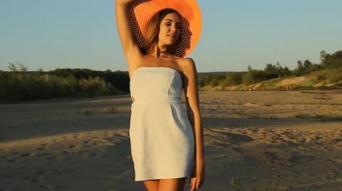 Girl posing on the shore in a hat Stock Footage 66724807