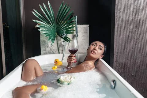 Girl posing while lying in a foam bath Foto stock