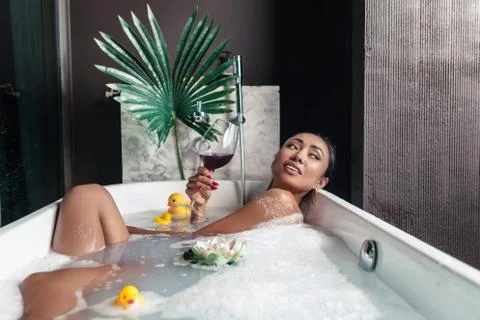 Girl posing while lying in a foam bath Foto stock