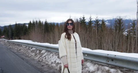 Girl posing on winter mountains background. Glamorous funny young woman with Stock Footage 131140817