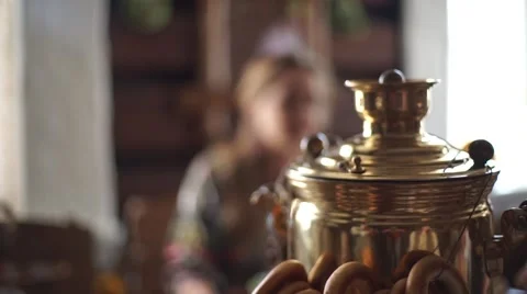 The girl pours tea from a samovar. A samovar with tea. Golden kettle. Bagels. Stock Footage