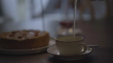 A girl pours tea on the table cake and candles Stock Footage 232419292