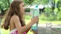 Girl pours water from a bottle into a glass HD Footage