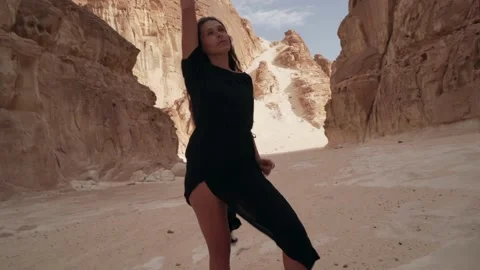 Girl practice ecstatic dance in desert. Dynamic active camera movement Stock Footage 130794761