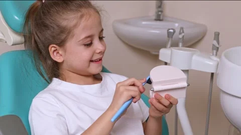 Girl is practicing how to properly brush her teeth. Good oral hygienist with jaw Stock Footage 307458049