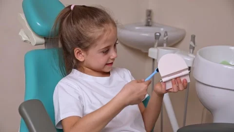 Girl is practicing how to properly brush her teeth. Good oral hygienist with jaw Stock Footage 307460148