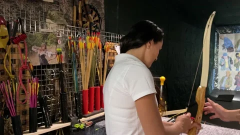 Girl practicing how to shoot with bow and arrows. Archer beginner. Video stock 160991967