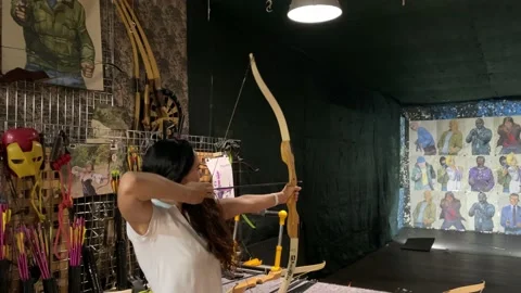 Girl practicing how to shoot with bow and arrows. Archer beginner. Video stock 170781387