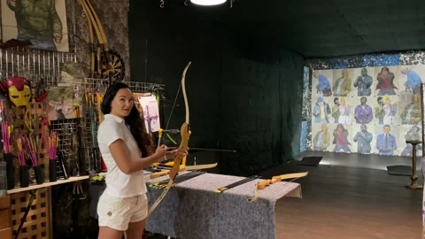 Girl practicing how to shoot with bow and arrows. Archer beginner. Video stock 197109185