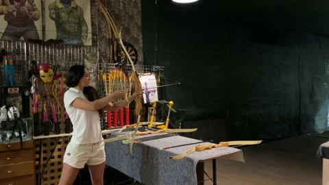 Girl practicing how to shoot with bow and arrows. Archer beginner. Video stock 197568078
