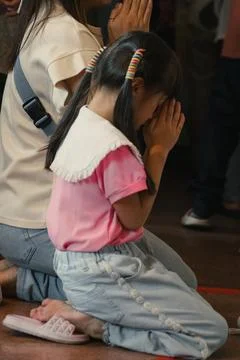 A girl praying inside a Buddhist temple in Bangkok, Thailand, 29 December, 2024 Stockfoto's