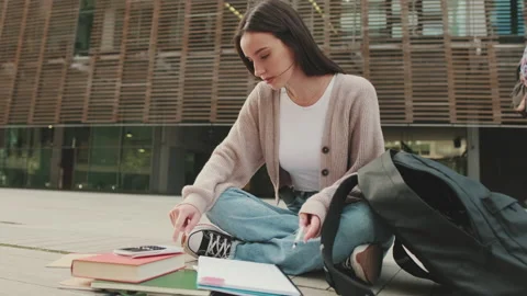 The girl is preparing for the exam, makes notes in a notebook Stock Footage 227386096