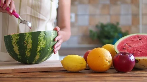Girl is preparing fresh watermelon on table in kitchen for smoothie. Stock Footage 92006041
