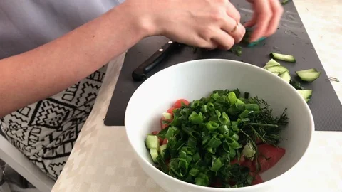 Girl preparing salad. greens puts in a plate Stock Footage