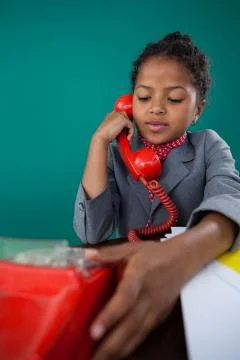 Girl pretending as businesswoman talking on land line phone Stock Photos