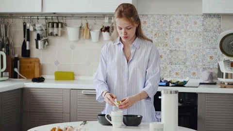 A girl with a problem skin breaks an egg with a knife. Separates the white from Stock Footage 147331007