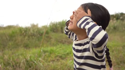 A Girl in Profile, Looking Up at the Sky While Being Rained On in a Meadow of Stock Footage 333185702