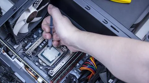 Girl programmer apply thermal paste on the computer processor, Foto stock