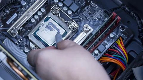 Girl programmer apply thermal paste on the computer processor, Stock Photos