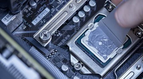 Girl programmer apply thermal paste on the computer processor, 库存照片