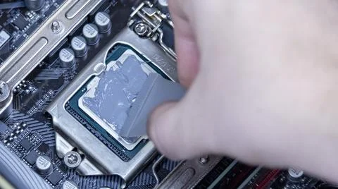 Girl programmer apply thermal paste on the computer processor, Stock Photos