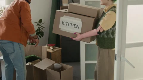 Girl with Prosthesis Bringing Boxes into Room, Boyfriend Taking Them from Her Stock Footage 323301153