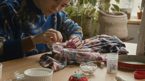 Girl with Prosthetic Arm Patching Up Clothes, Working in Thrift Store Video stock 328361925