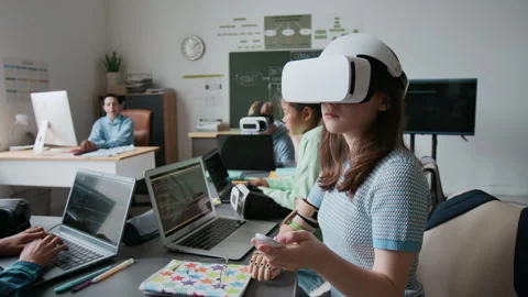 Girl with Prosthetic Arm Using VR, Others Working on Laptops During IT class Stock Footage 317648047