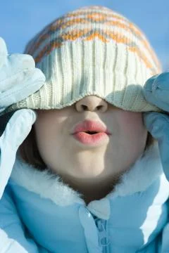 Girl pulling knit hat down over eyes, puckering, close-up Stock Photos