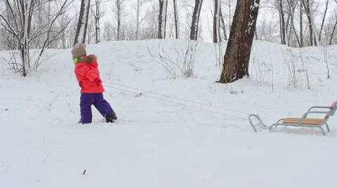 Girl pulling a rope on a snow sled Video stock 68938855