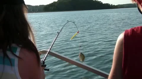 Girl Pulls in Fish from Boat Stock Footage 12583601