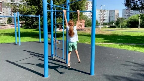 Girl pulls herself up on the horizontal bar Video stock 160032134