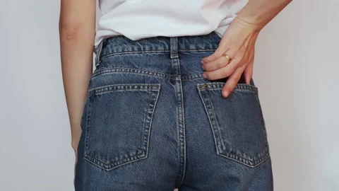 A girl pulls out a smartphone from the back pocket of her jeans. Stock Footage 306222079
