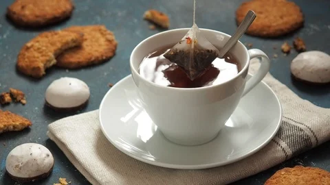 Girl pulls out a tea bag from a white cup. Still life with cookies Stock Footage 104974907
