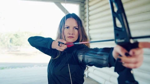 Girl pulls string and aims arrow Stock Footage 81927040
