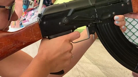 A girl pulls the trigger of an air rifle in a shooting gallery 動画素材 153286850
