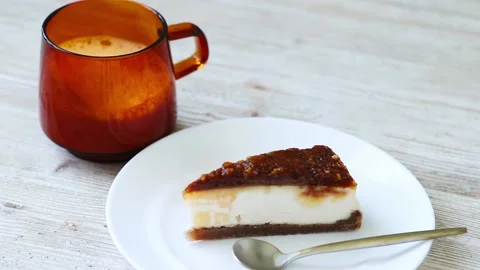 The girl puts a cheesecake with pecans on the table next to a cup of coffee Stock Footage 163177734