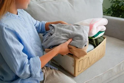 The girl puts clothes in donation box Stock Photos