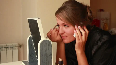 Girl Puts Makeup and Talking on Phone 1 Stock Footage 33653898