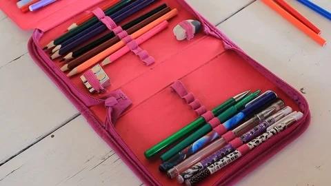 Girl puts pencils in a pencil case Stock Footage