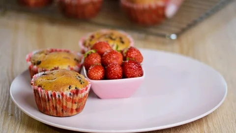 Girl puts a plate of muffins Stock Footage